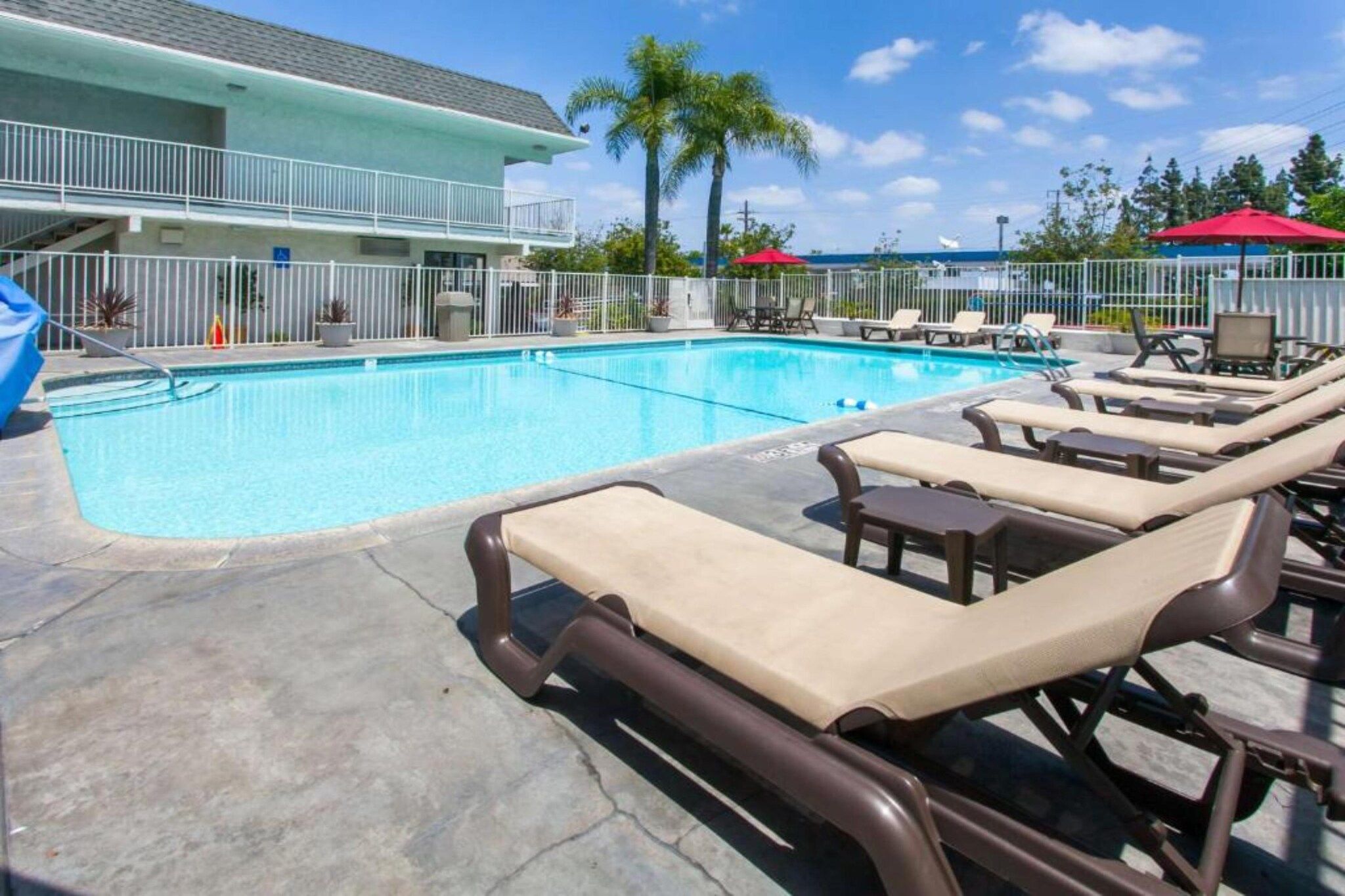 A swimming pool with lounge chairs and a building in the background.