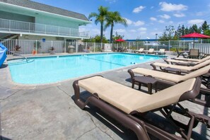 A swimming pool with lounge chairs and a building in the background. - 2 Full Beds | Micfridge (Rosemead)
