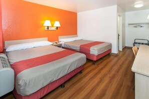 Une chambre d’hôtel avec deux lits, un bureau et une chaise.