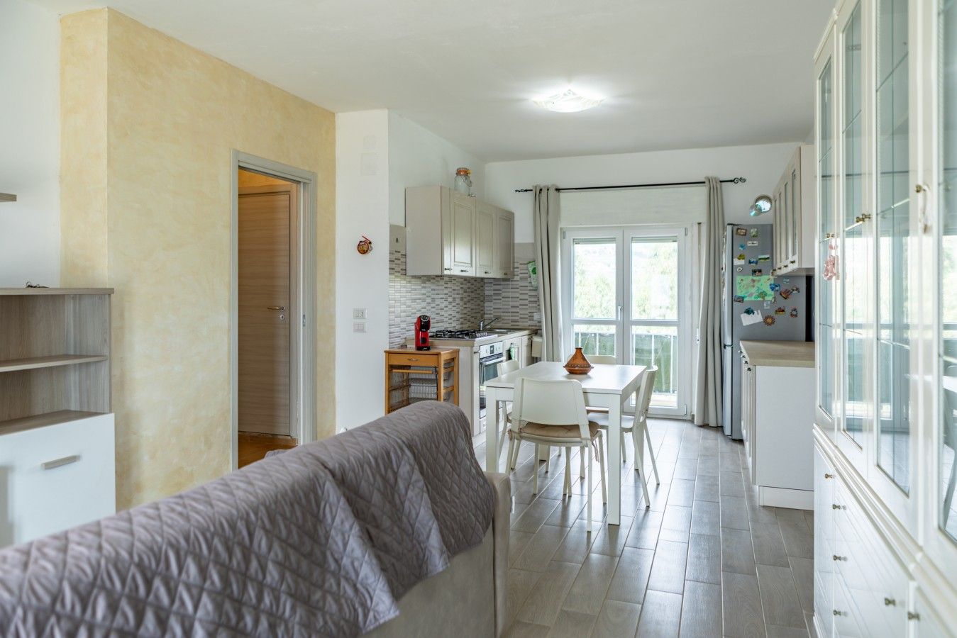 Een functionele woonruimte met kitchenette, eethoek en een bank.