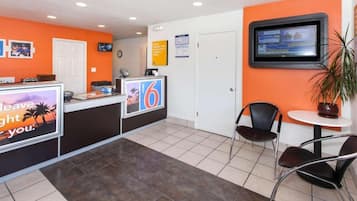 A reception area with a counter, a television, and seating.