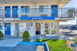 Ein zweistöckiges Gebäude mit einer blauen Markise und einem 'welcome'-Schild.