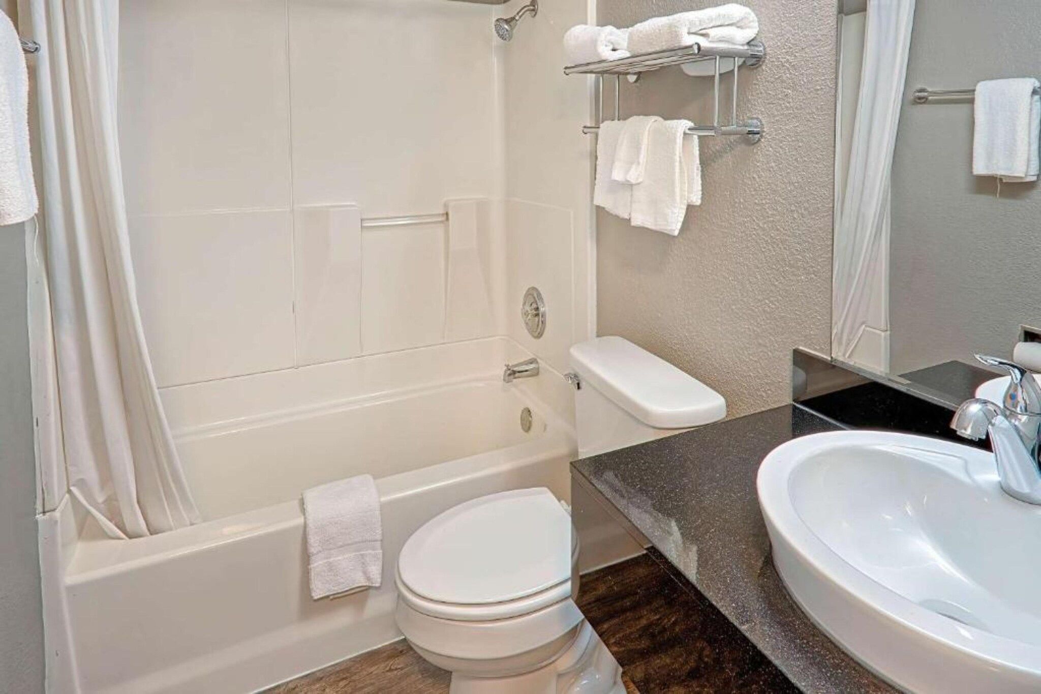 A bathroom with a bathtub, toilet, and sink.