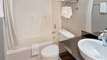 A bathroom with a bathtub, toilet, and sink.
