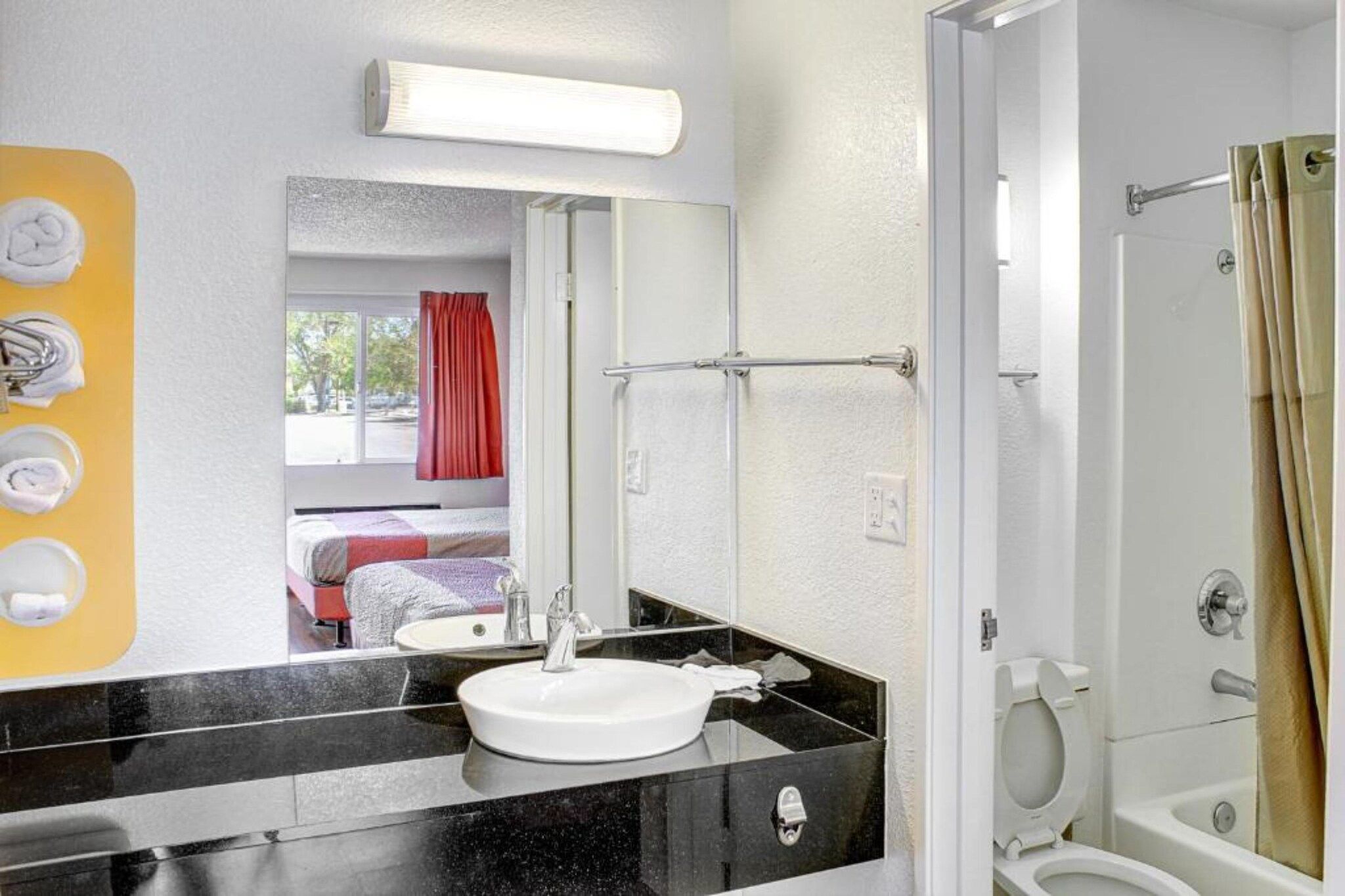 A hotel bathroom with a sink, toilet, and shower.