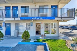 Un edificio de dos pisos con un toldo azul y un letrero que dice 'welcome'.