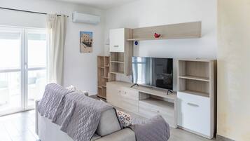 Ein modernes Wohnzimmer mit einer Couch, einem Fernseher und Einbauschränken.