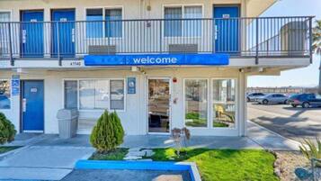 Ein zweistöckiges Gebäude mit einer blauen Markise und einem 'welcome'-Schild.