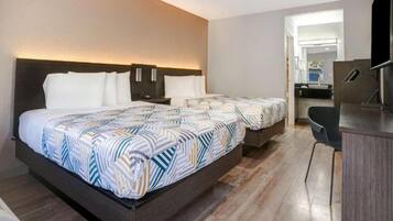 A hotel room with a large bed, a desk, and a chair.