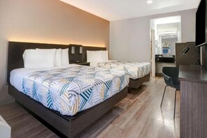 Una habitación de hotel con una cama grande, un escritorio y una silla.