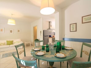 A dining area with a round table, chairs, and a refrigerator in the background. - Beautiful private villa for 6 people with A/C, WIFI, TV and patio (Forte Dei Marmi)