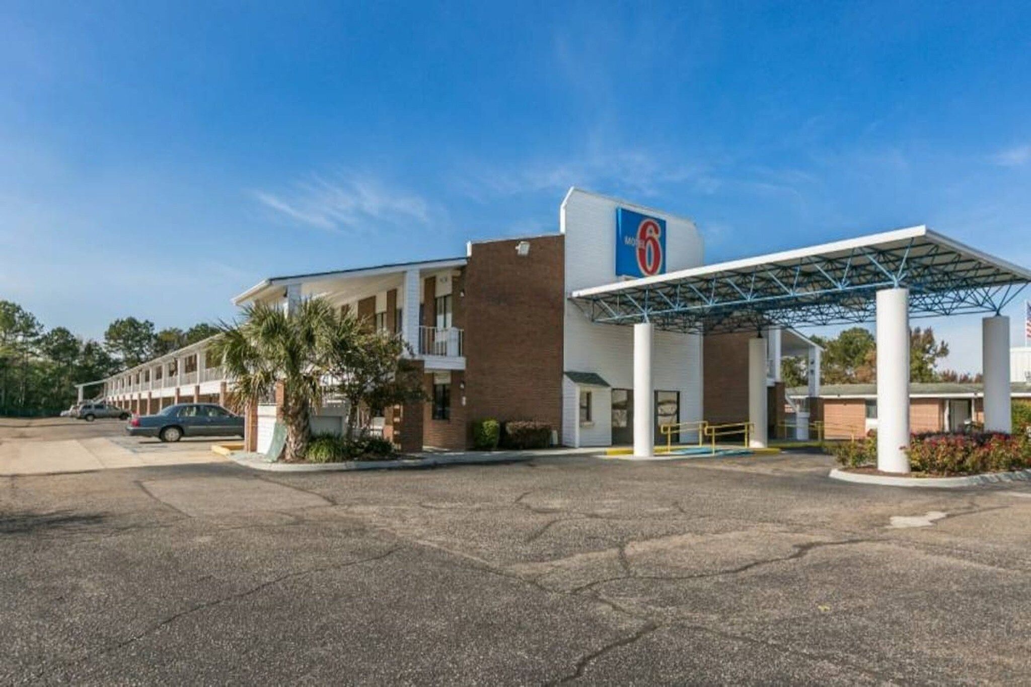 A motel with a gas station, a covered parking area, and a building with a '6' logo.