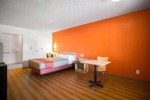 Hotellihuone, jossa on sänky, työpöytä ja tuoli.