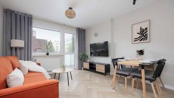 Un salon moderne avec un canapé, une table à manger et un téléviseur.