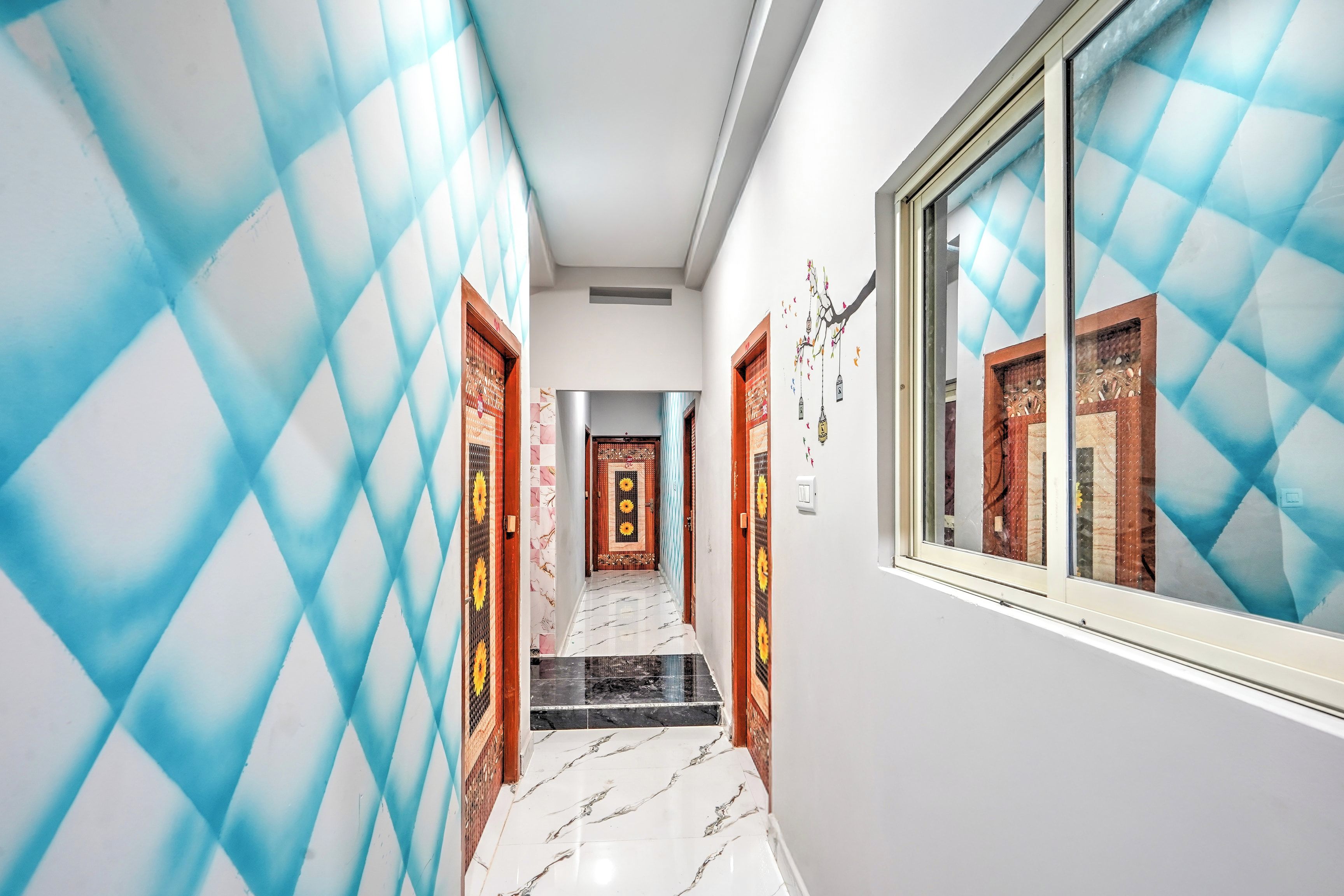 A hallway with patterned walls, a tiled floor, and doors with traditional designs.