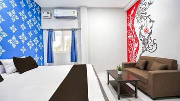 Habitación de hotel con cama, sofá, mesita de café y decoración en la pared.