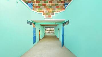 Un couloir avec un mur recouvert de carreaux et des portes bleues.