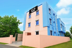 Un edificio de hotel de varios pisos con un cartel que indica que cuenta con servicios de Oyo.