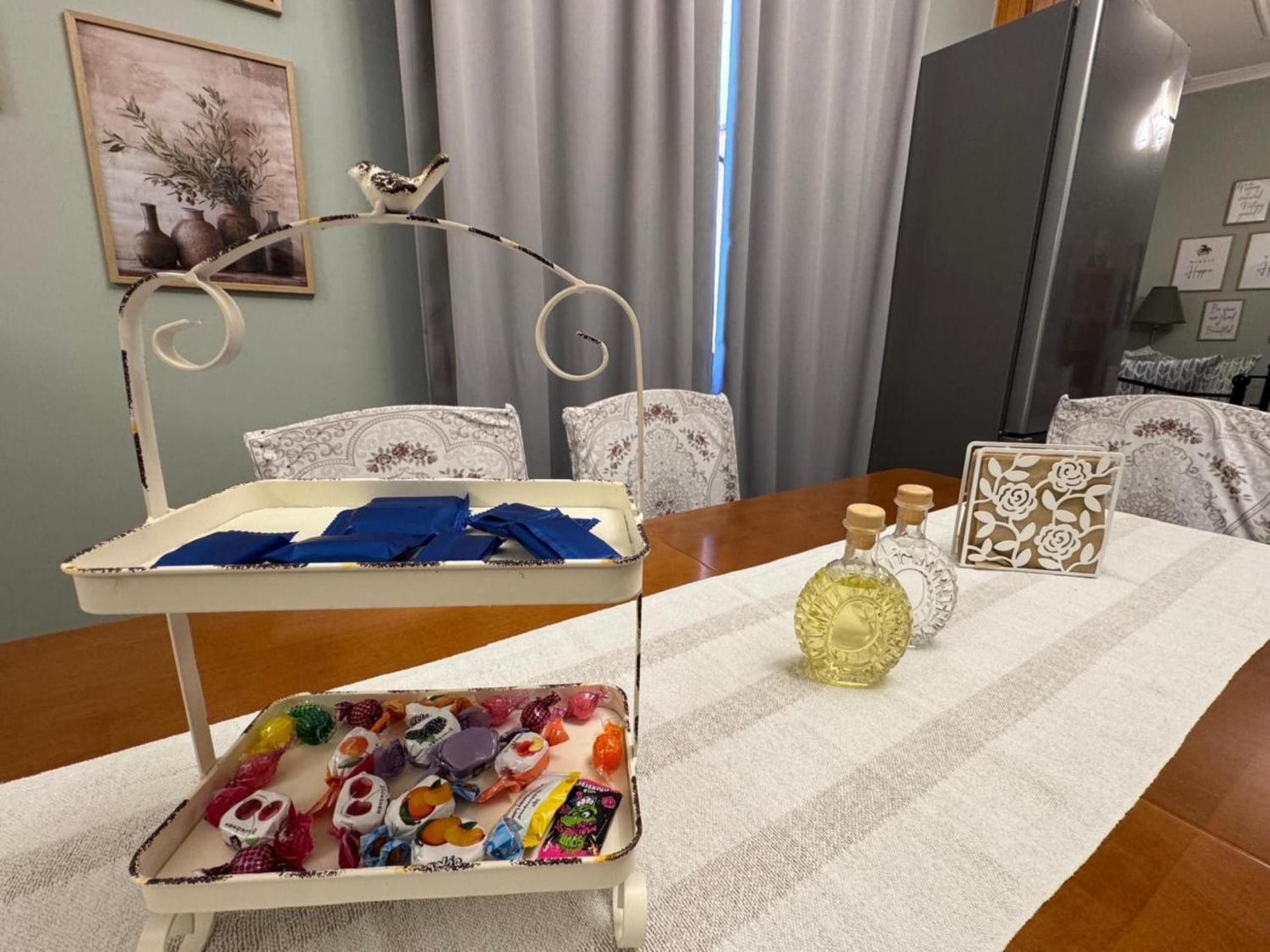 A room with a dining table set with a tray, bottles, and a decorative item.