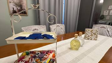 A room with a dining table set with a tray, bottles, and a decorative item.