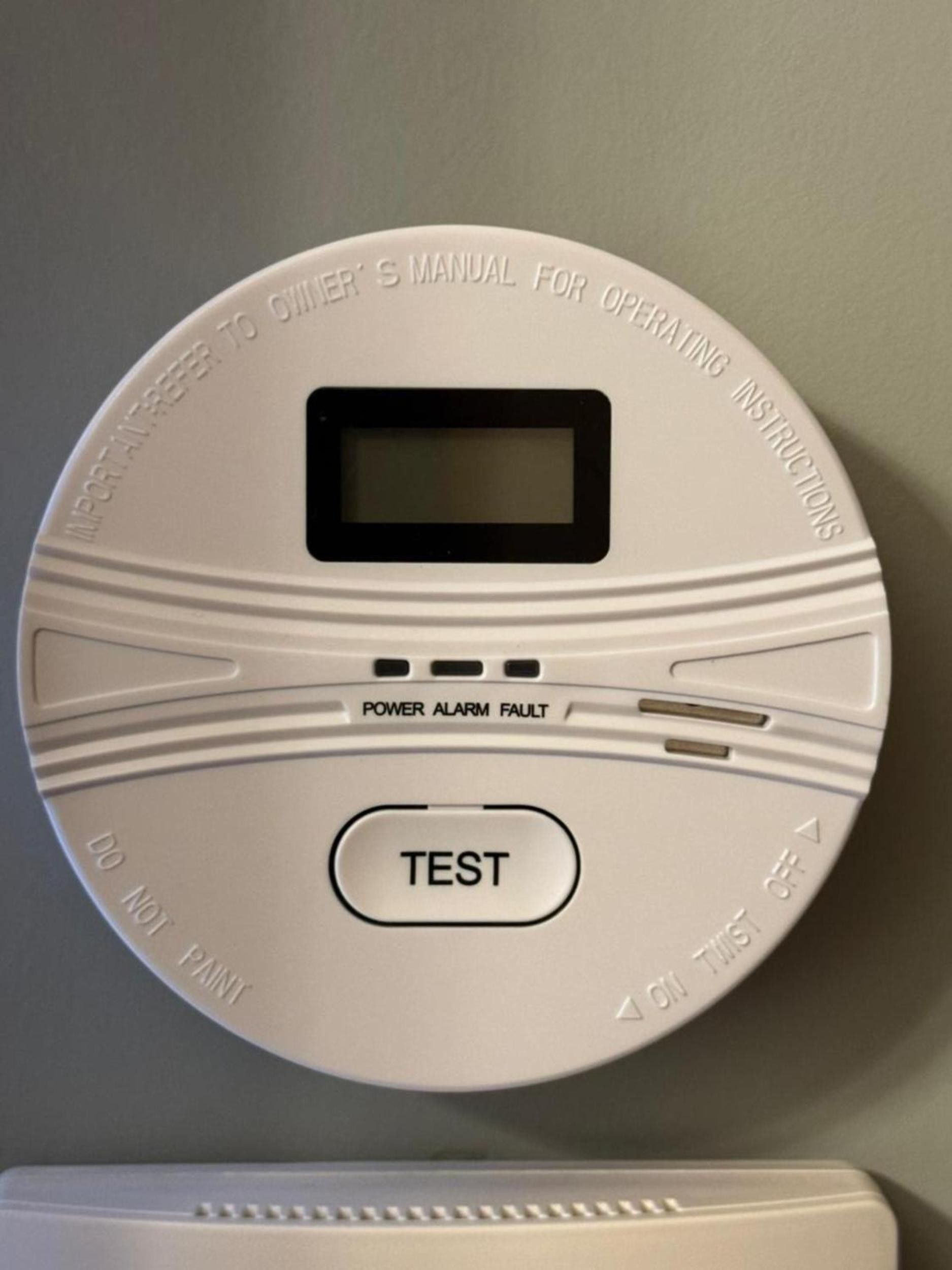 A smoke detector with a test button and a power alarm fault indicator.