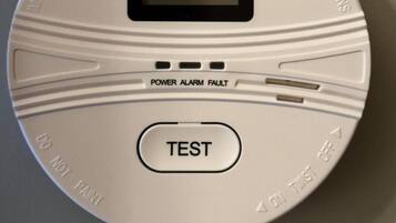 A smoke detector with a test button and a power alarm fault indicator.