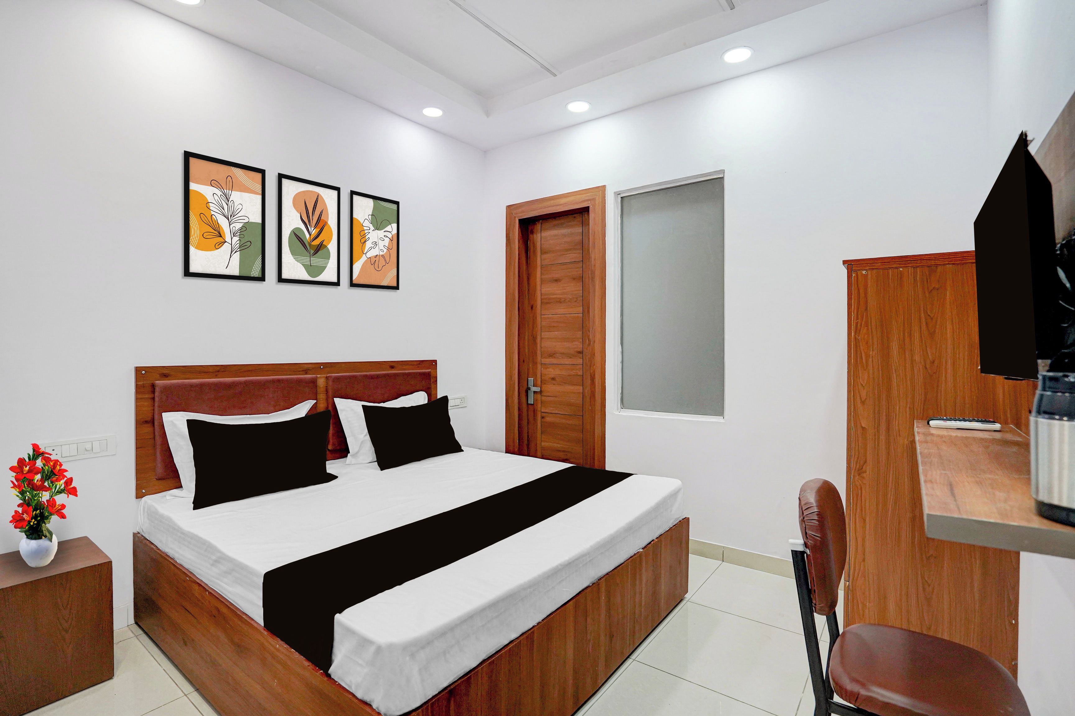 Una habitación de hotel con una cama de madera, un escritorio, una silla y un televisor.