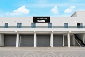 A modern building with a sign reading 'TOWNHOUSE' and 'OYO-Serviced'.