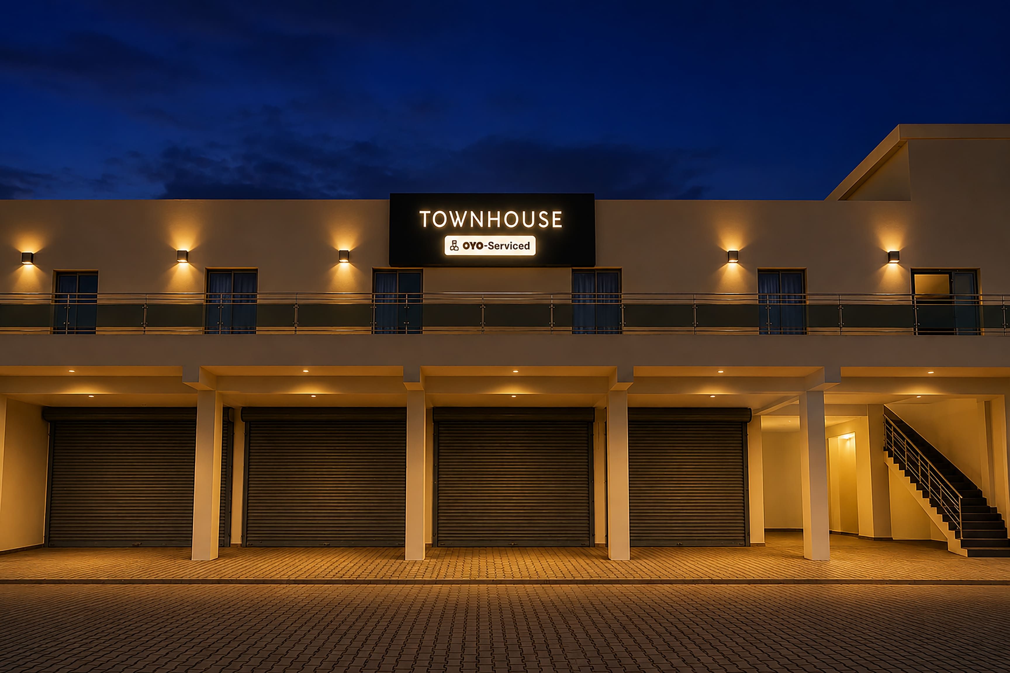 Un edificio de varios pisos con un letrero que dice 'TOWNHOUSE' y 'OYO-Serviced'.