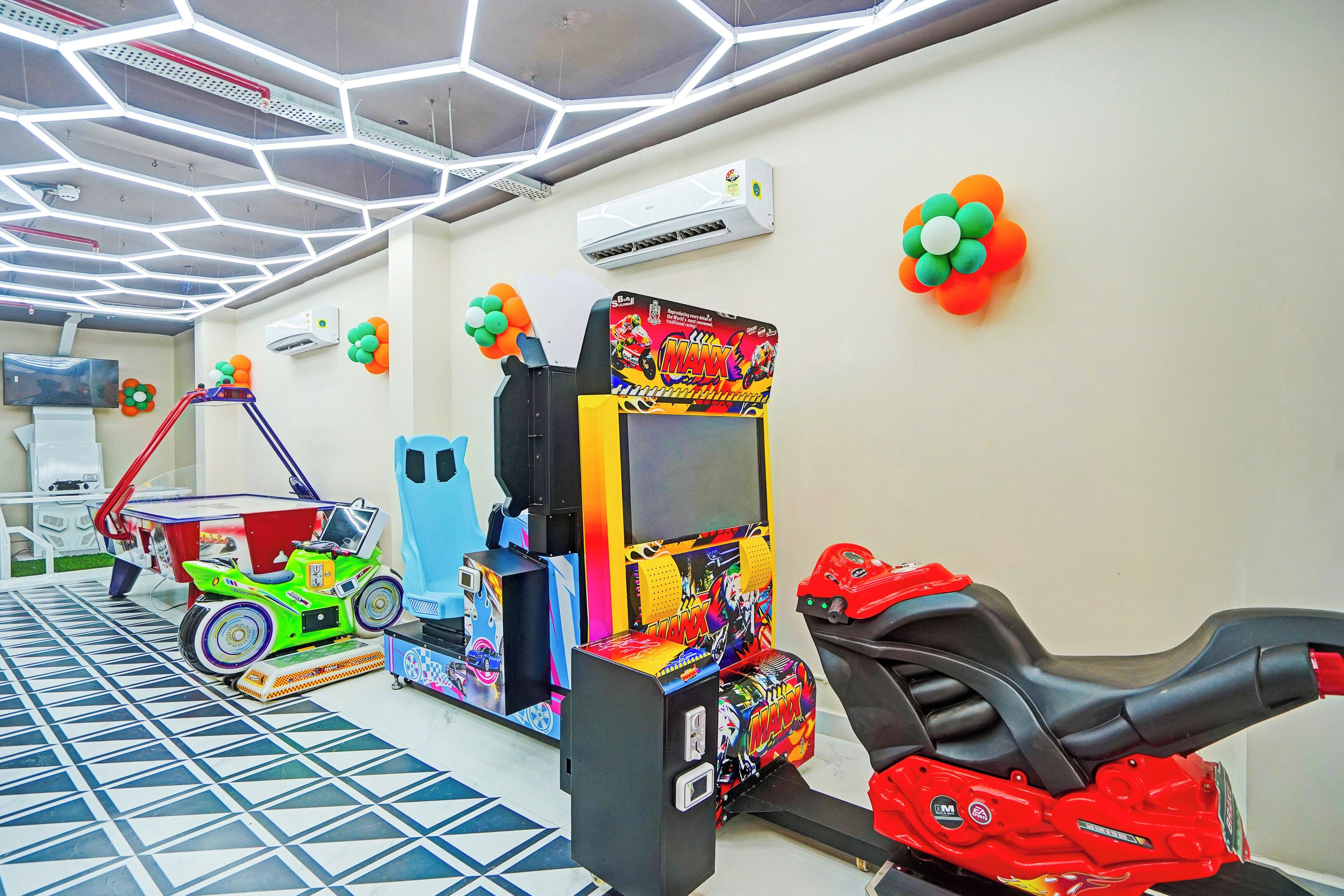 Una habitación con juegos de arcade, televisión y piso con estampado.