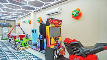Una habitación con juegos de arcade, televisión y piso con estampado.
