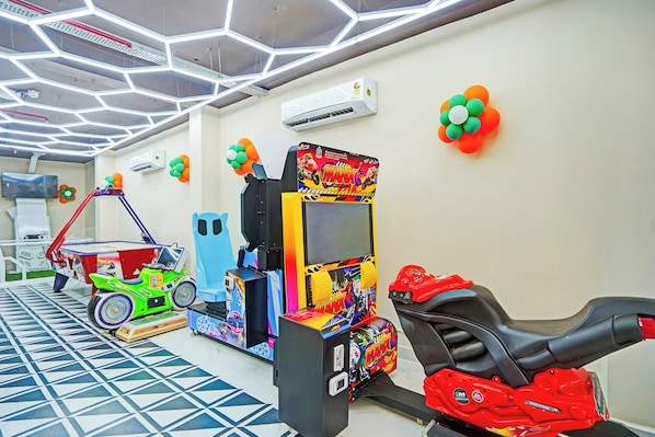 Una habitación con juegos de arcade, televisión y piso con estampado.