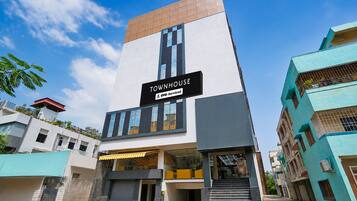 A modern building with a sign reading 'TOWNHOUSE' and 'OYO-Serviced'.