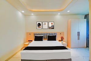 A modern hotel room with a large bed, a wardrobe, and artwork on the wall. - Townhouse Patna Airport (Patna)
