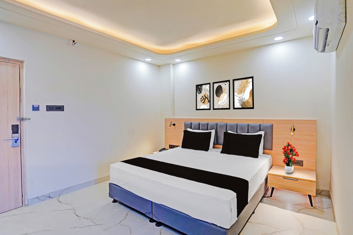 Un dormitorio moderno con cama, mesitas de noche, una lámpara de pared y una puerta.