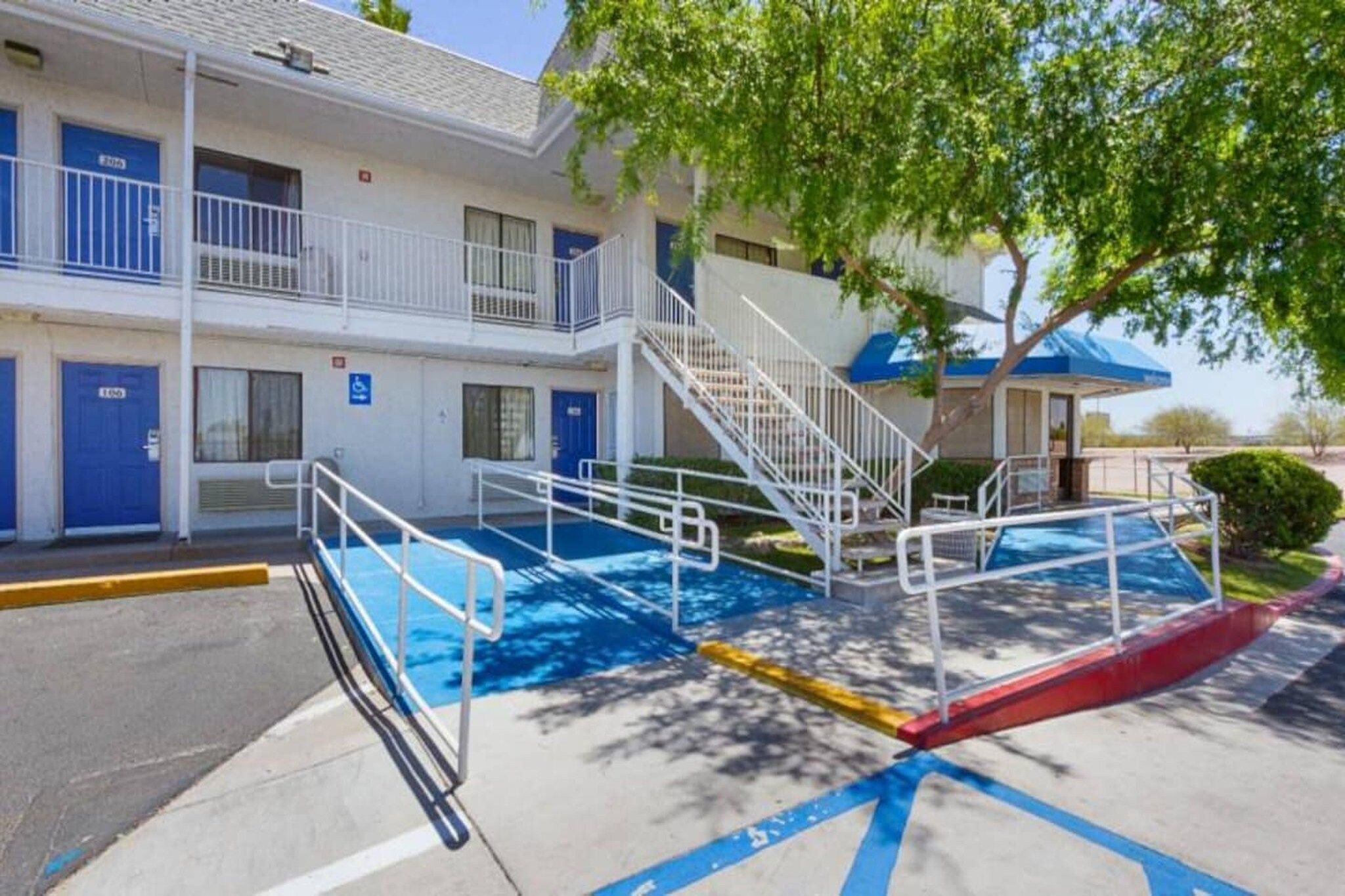 A motel with a pool area, including a wheelchair-accessible ramp and stairs.