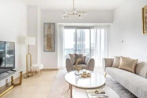 Een moderne woonkamer met een bank, salontafel en een televisie.