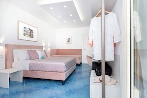A modern bedroom with a double bed, bedside tables, a wardrobe, and a hanging robe. - Cornelia Rooms (Sorrento)