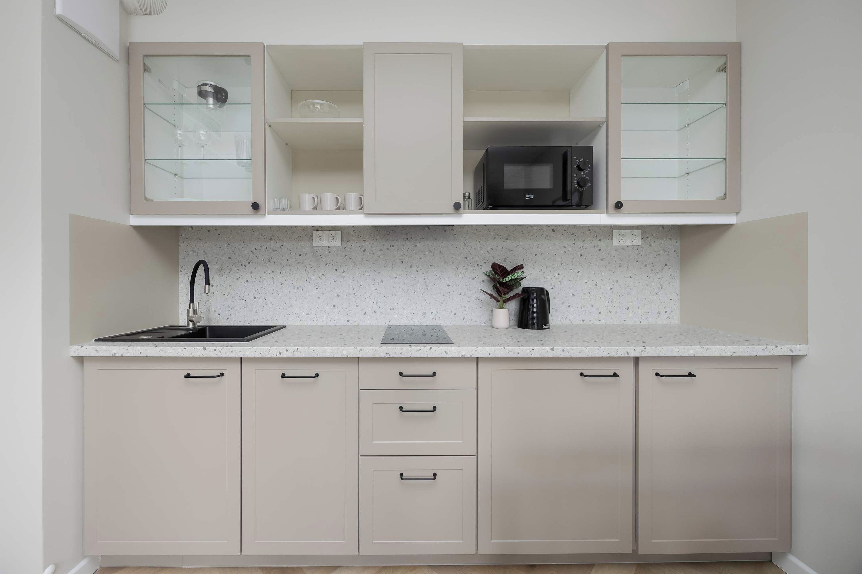 A kitchen with a stainless steel sink, a microwave, and a coffee maker on the countertop.