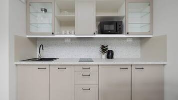 A kitchen with a stainless steel sink, a microwave, and a coffee maker on the countertop.