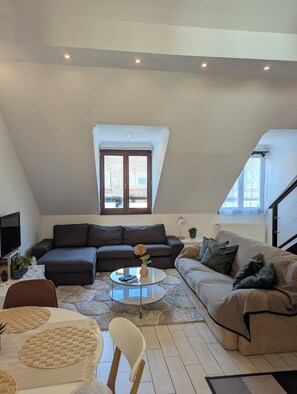 A modern living room with a sectional sofa, a coffee table, and a TV. - Astoria Panorama Duplex, Self-check-in, Automated, Large, 2lvl apt with a view (Budapest)