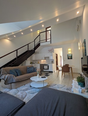 A modern living space with a staircase, a sofa, a dining area, and a kitchen. - Astoria Panorama Duplex, Self-check-in, Automated, Large, 2lvl apt with a view (Budapest)