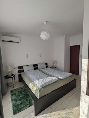 A modern bedroom with a bed, bedside tables, a green rug, and a ceiling light fixture. - Astoria Panorama Duplex, Self-check-in, Automated, Large, 2lvl apt with a view (Budapest)