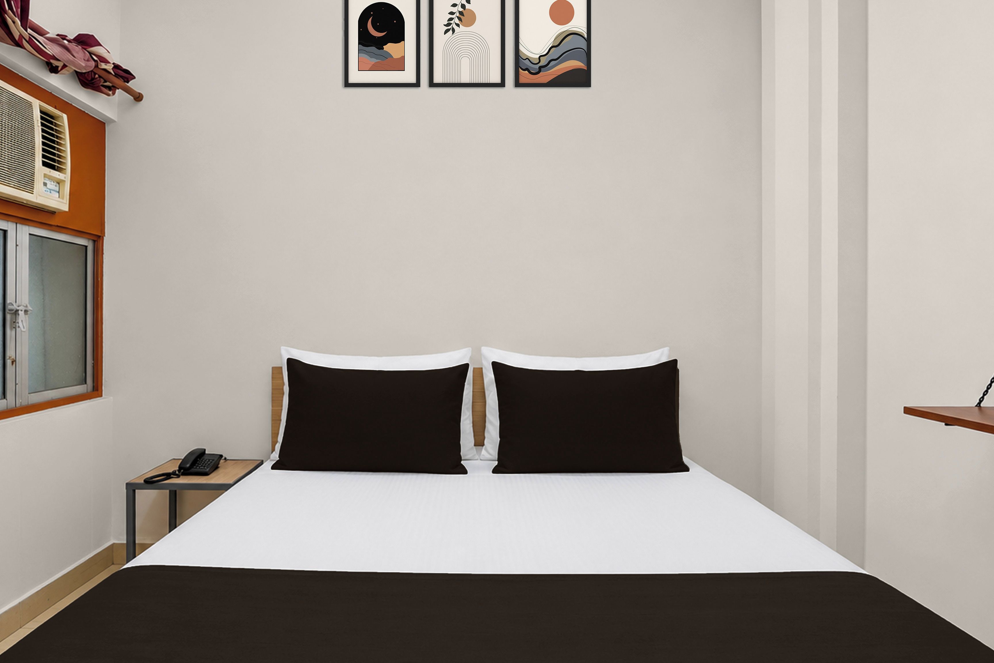 Una habitación de hotel con una cama, una mesita de noche con teléfono y una ventana con persianas.