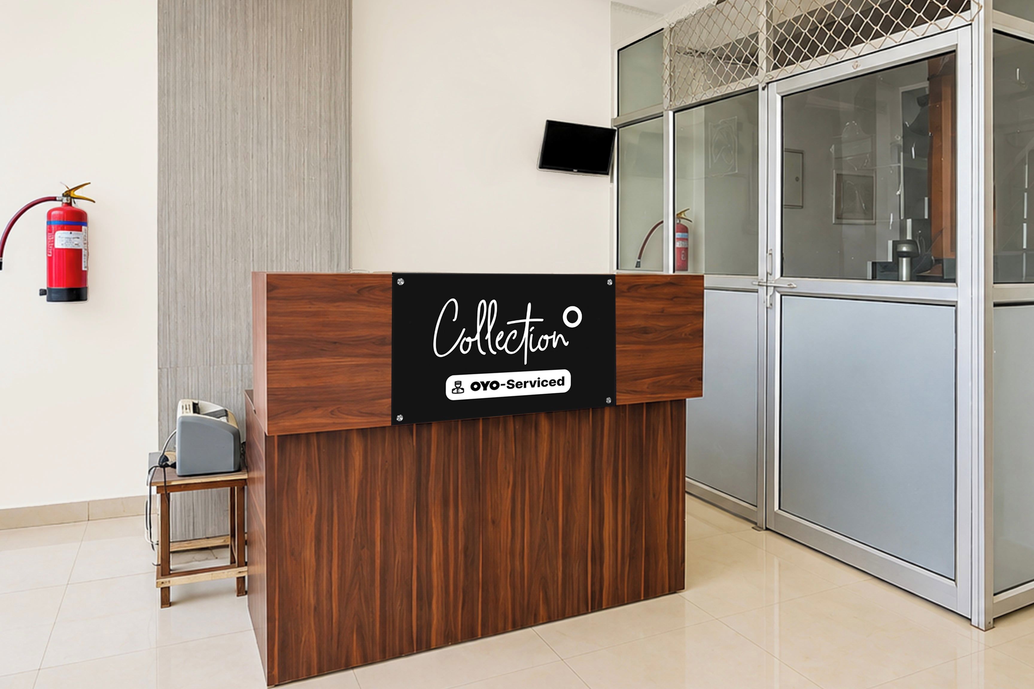 Una mesa de recepción con un cartel que dice 'Collection OYO-Serviced'.
