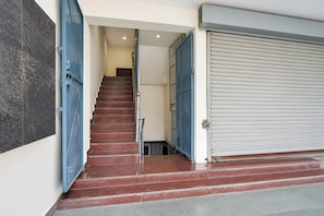 Una escalera que conduce a una habitación con una puerta de garaje cerrada.