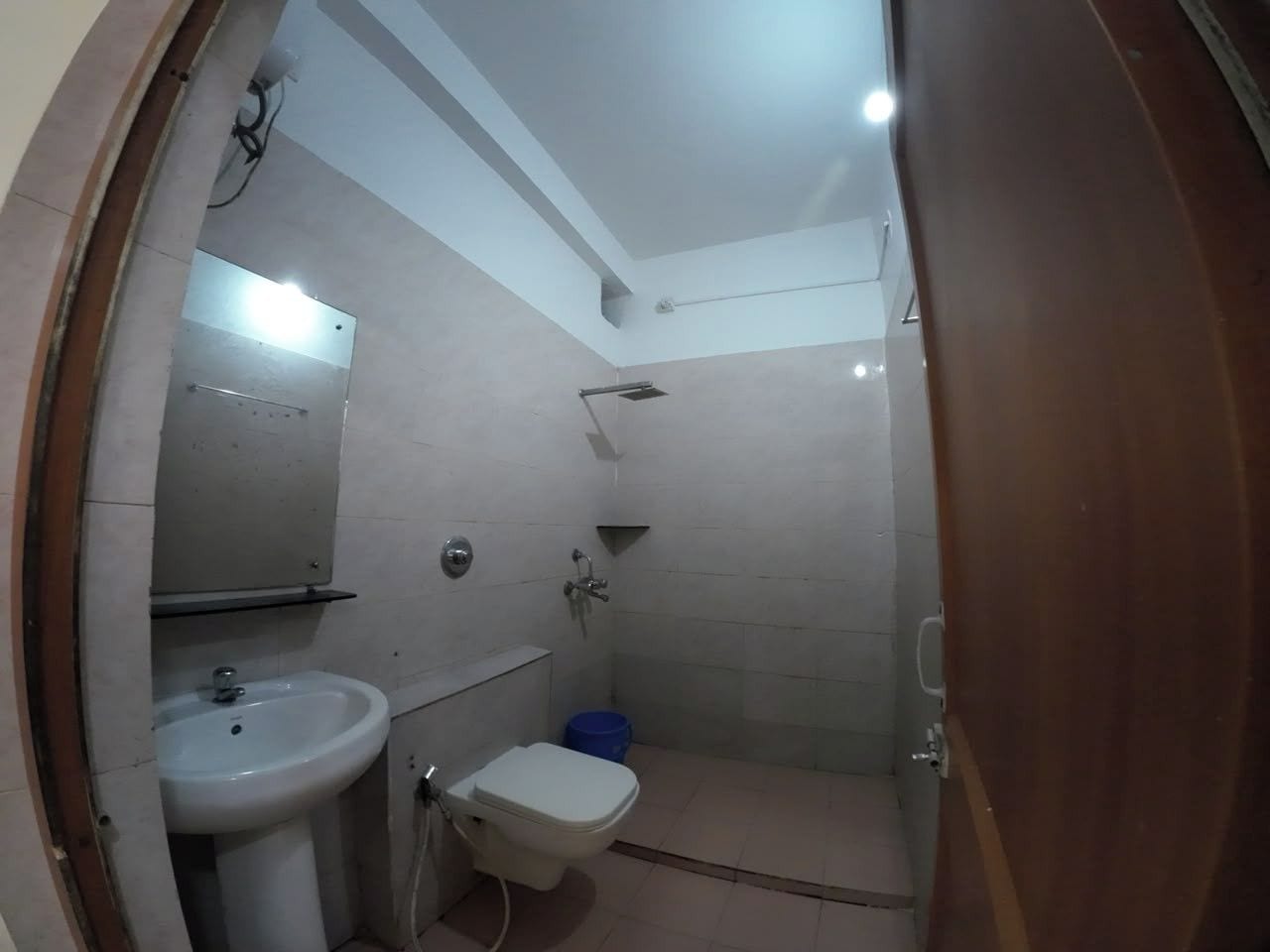 Een compacte badkamer met een wastafel, toilet en douche.