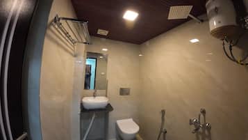 Un baño con lavamanos, inodoro, ducha y espejo.