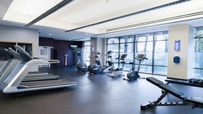 A modern gym with treadmills, elliptical machines, and a bench. - WorldMark Anaheim - 1BR Suite, Rooftop Hot Tub Near Disneyland (Anaheim)