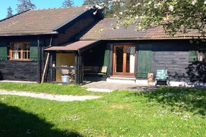 Ein Holzhaus mit Veranda, Fenster und Tür.